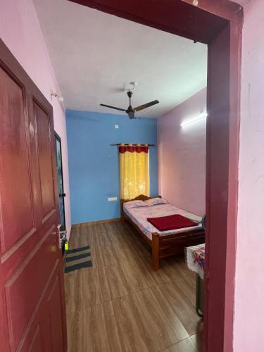 a bedroom with a bed and a ceiling fan at HostelExp, Varkala - A Beach Town Hostel in Varkala