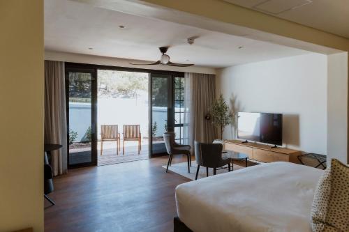 a hotel room with a bed and a desk and a television at Laborie Estate in Paarl