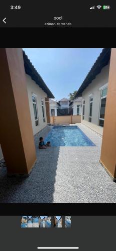 a person laying on the ground next to a swimming pool at D Aur Poolvilla Seaview in Bachok