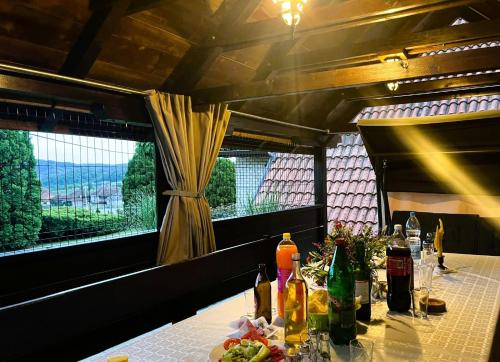 a table in a restaurant with bottles and flowers on it at Seosko turističko domaćinstvo Jolović GUČA Veles in Guča