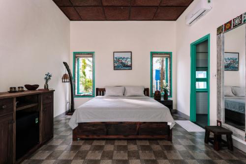 a bedroom with a bed and some windows at Lamer Coastal Villa in Hoi An
