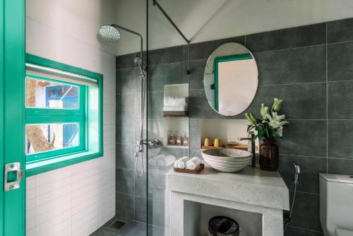 a bathroom with a shower and a sink and a mirror at Lamer Coastal Villa in Hoi An