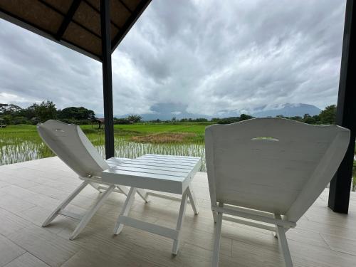 a white chair sitting on a porch next to a field at บ้านผ่อดอยกอยดาวพรีเมี่ยม in Ban Sop Nong