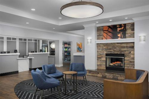 a living room with a fireplace and blue chairs at Homewood Suites by Hilton Birmingham South Inverness in Hoover