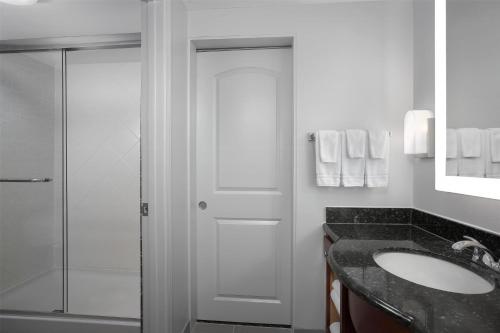 a bathroom with a sink and a glass shower at Homewood Suites by Hilton Birmingham South Inverness in Hoover