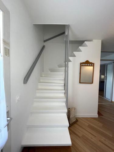 - un escalier dans une maison avec un miroir sur le mur dans l'établissement Nice 120m with garden near the sea, à Sainte-Marie de Ré