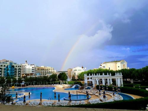 a rainbow in the sky over a large swimming pool at Apartment Sunset resort C8-24 in Pomorie