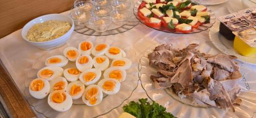 a table with eggs and meat and a plate of food at Hotel Alpina in Bad Reichenhall