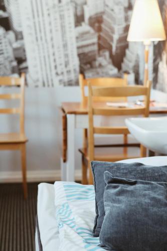 a bed with a pillow and a table and chairs at Hostelli Marja in Mikkeli