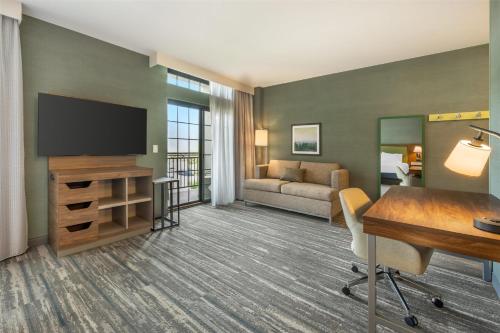 a living room with a flat screen tv in a hotel room at Hampton Inn and Suites Coeur d'Alene in Coeur d'Alene