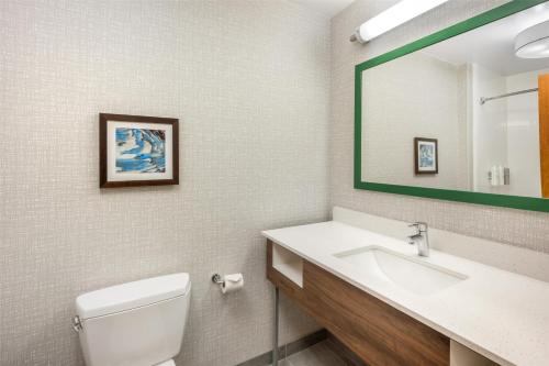 a bathroom with a sink and a toilet and a mirror at Hampton Inn and Suites Coeur d'Alene in Coeur d'Alene