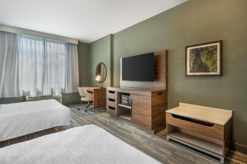 a hotel room with a bed and a flat screen tv at Hampton Inn and Suites Coeur d'Alene in Coeur d'Alene