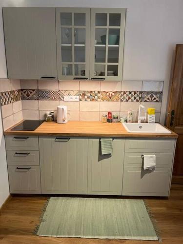a kitchen with white cabinets and a sink at Apartmán Jimi Hendrix in Nymburk
