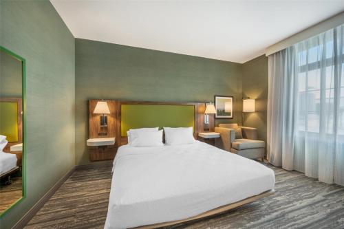 a bedroom with a large white bed and a chair at Hampton Inn and Suites Coeur d'Alene in Coeur d'Alene