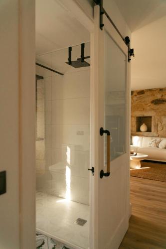a glass door leading into a bathroom with a bedroom at O Rio Da Meiga in Beloso