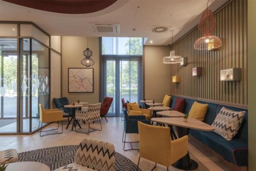 a restaurant with tables and chairs and windows at Hampton By Hilton Dresden City Centre in Dresden