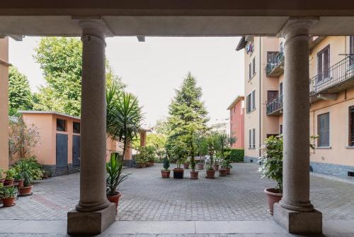 a courtyard with potted plants and buildings at GuestHost - Cozy Loft-Studio Flat in Crescenzago in Milan