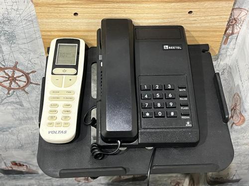 a black phone with a cell phone at Kishan Home Stay in Mathura