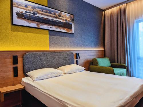 a hotel room with a bed and a chair at Qubus Hotel Bydgoszcz in Bydgoszcz