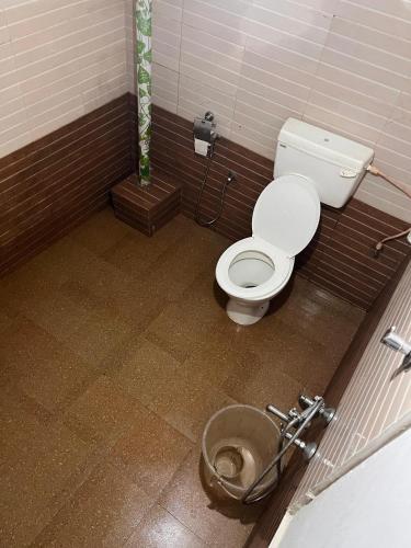 a bathroom with a toilet in a stall at HostelExp, Varkala - A Beach Town Hostel in Varkala