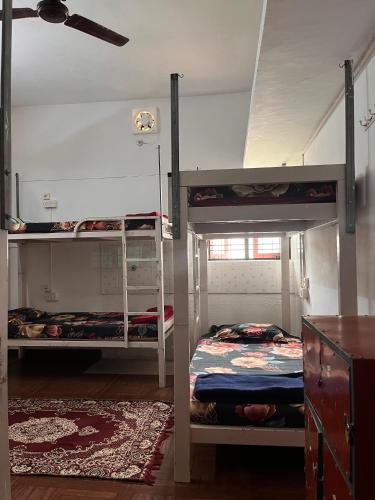 a bedroom with two bunk beds and a ceiling at HostelExp, Varkala - A Beach Town Hostel in Varkala