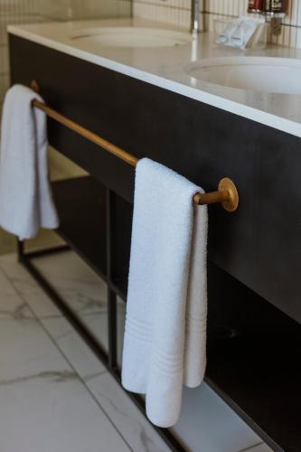 two towels hanging on a towel rack next to a sink at Laborie Estate in Paarl