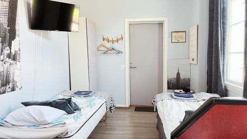 two beds in a small room with a door at Hostelli Marja in Mikkeli