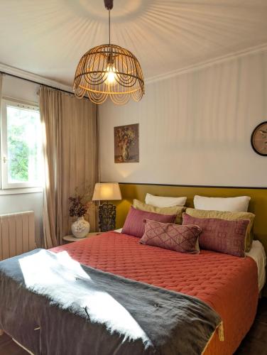 une chambre avec un grand lit avec une couette rouge dans l'établissement EtxeCosy Maison Piscine à Bidart, à Bidart