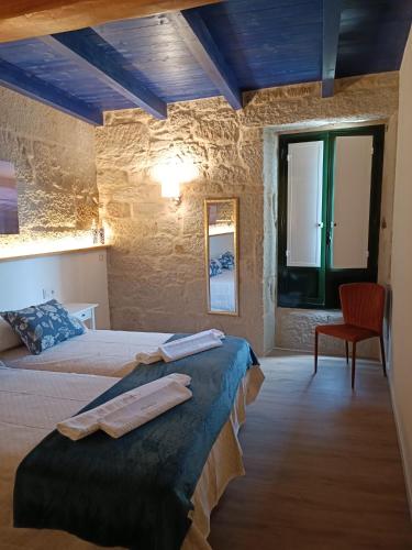 a bedroom with two beds and a red chair at Noelmar II Combarro in Combarro