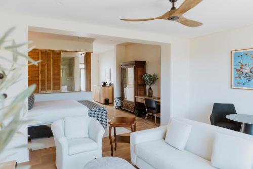a living room with a white couch and chairs at Laborie Estate in Paarl