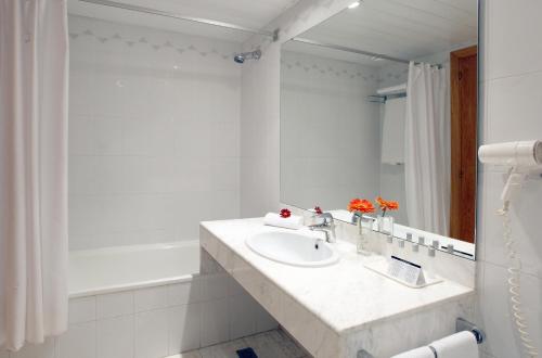 a white bathroom with a sink and a mirror at Ciutat de Granollers in Granollers
