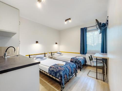 a hospital room with two beds and a sink at Arcus Premium Hostel in Warsaw
