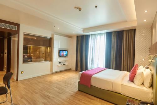 a hotel room with a bed and a television at Tania President Inn in Shirdi