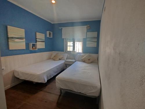 two beds in a room with blue walls at LaGreenHouse in Lliria