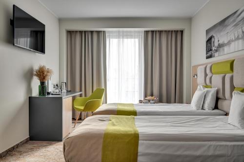 a hotel room with two beds and a desk at HOTEL ALMOND BUSINESS & SPA BY GRANO - GRANO HOTEL Gdańsk Riverside in Gdańsk