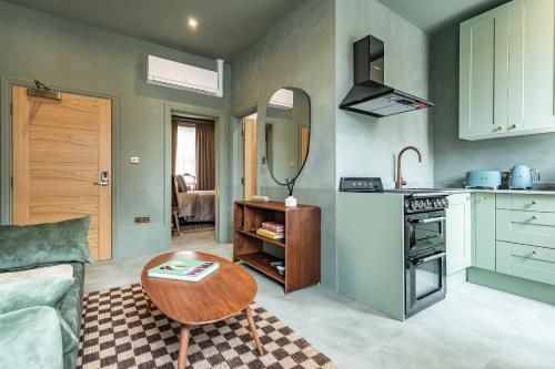 a living room with a table and a kitchen at Maison Rokxy - Luxury Apartments in London