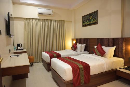 a hotel room with two beds and a television at Hotel dayss Inn in Varanasi