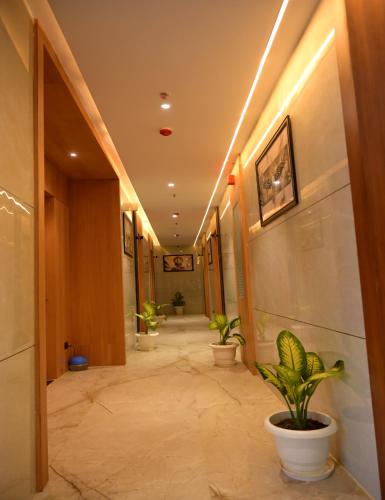 a corridor with potted plants in a hallway at Hotel dayss Inn in Varanasi