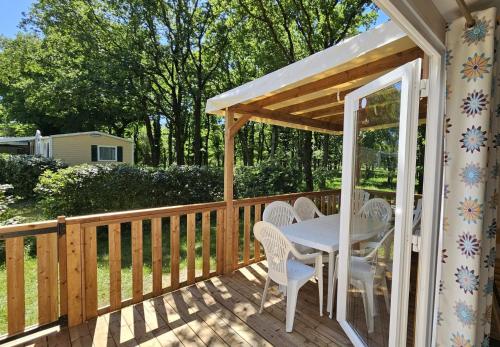 une terrasse en bois avec une table et des chaises dessus dans l'établissement MH-MAUFAY -- Mobil-Home -- Puy du Fou - 30 min, à La Boissière-de-Montaigu