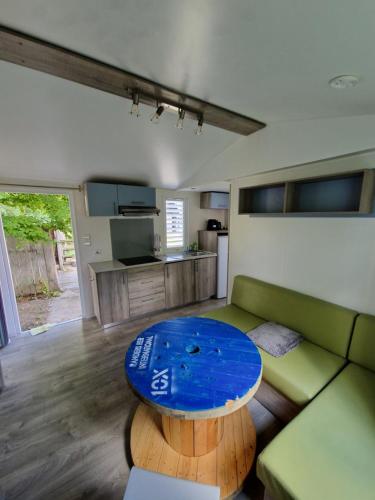 un soggiorno con divano e tavolo di Le Bungalow a Saint-Germain-du-Bois