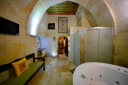 a bathroom with a bath tub in a building at Ürgüp Inn Cave Hotel in Urgup