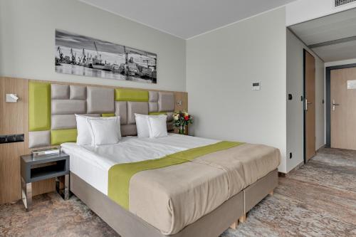 a bedroom with a large bed in a room at HOTEL ALMOND BUSINESS & SPA BY GRANO - GRANO HOTEL Gdańsk Riverside in Gdańsk