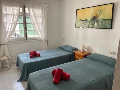 two beds in a room with red pillows on them at Es Castell 1 7 by SOM Menorca in Fornells