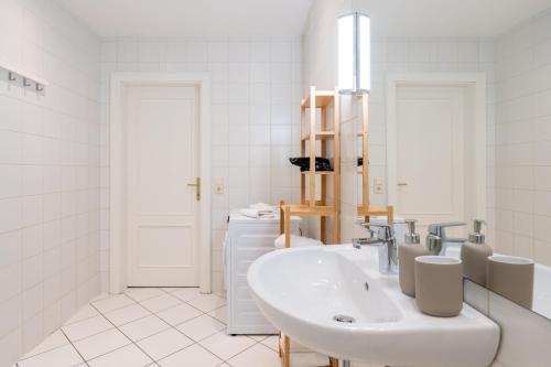 a white bathroom with a sink and a mirror at Vienna Central Panorama in Vienna