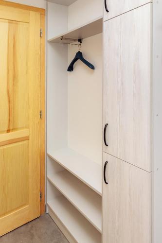 a closet with white shelves and a door at Arcus Premium Hostel in Warsaw