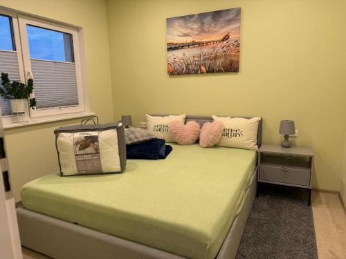 a bedroom with a bed with pillows on it at Aerodromas K3 in Palanga