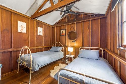 - 2 lits dans une chambre dotée de lambris dans l'établissement Country Cottage Sunshine Coast, à Montville