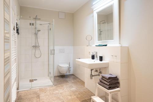 a white bathroom with a sink and a shower at Storchenhof Blumenow in Blumenow