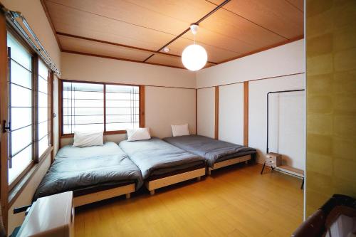 Un dormitorio con una cama grande en una habitación con ventanas. en Kotobuki, en Otaru