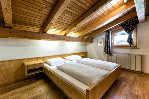 a large bed in a room with a wooden ceiling at Appartementanlage Kerber in Seefeld in Tirol